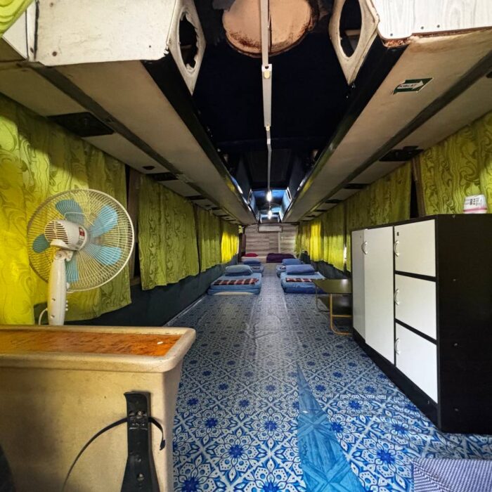 Ruang tamu dalam Bas Sunflower dengan dekorasi hijau dan katil tambahan di KSCC.