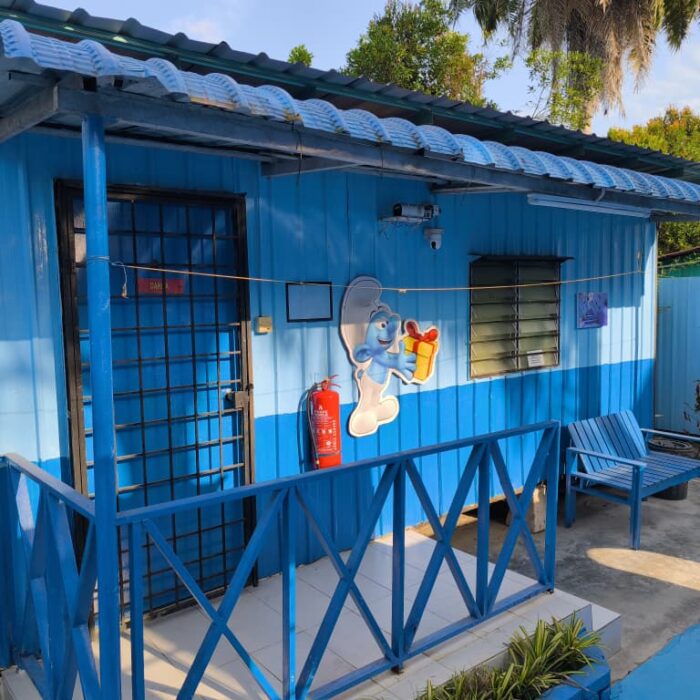 Bahagian luar unit CabinStay Biasa dengan pintu biru dan hiasan watak Smurf.