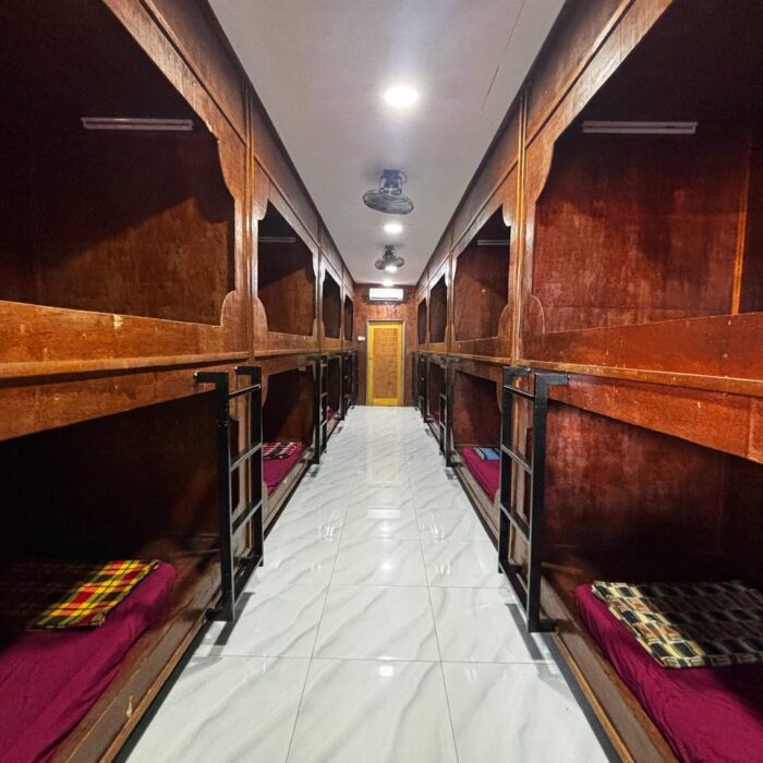 Pandangan lorong dalaman unit Capsule Stay dengan deretan katil kapsul yang disusun rapi di Kuala Selangor Cabin Camp (KSCC).