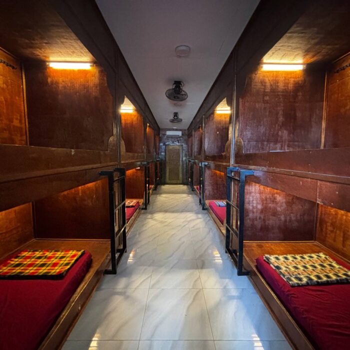 Lorong di dalam unit Capsule Stay dengan deretan ruang tidur berbentuk kapsul kayu di Kuala Selangor Cabin Camp (KSCC).