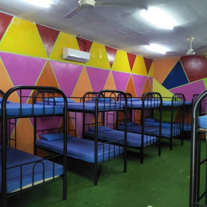 Suasana bilik Dormstay yang luas dengan dinding berwarna-warni dan banyak katil bertingkat di Kuala Selangor Cabin Camp (KSCC).