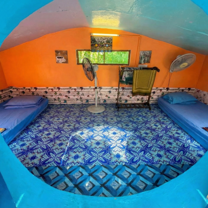 Ruang dalaman unit Hobbitstay dengan susunan katil yang selesa dan dekorasi dinding yang unik di Kuala Selangor Cabin Camp (KSCC).