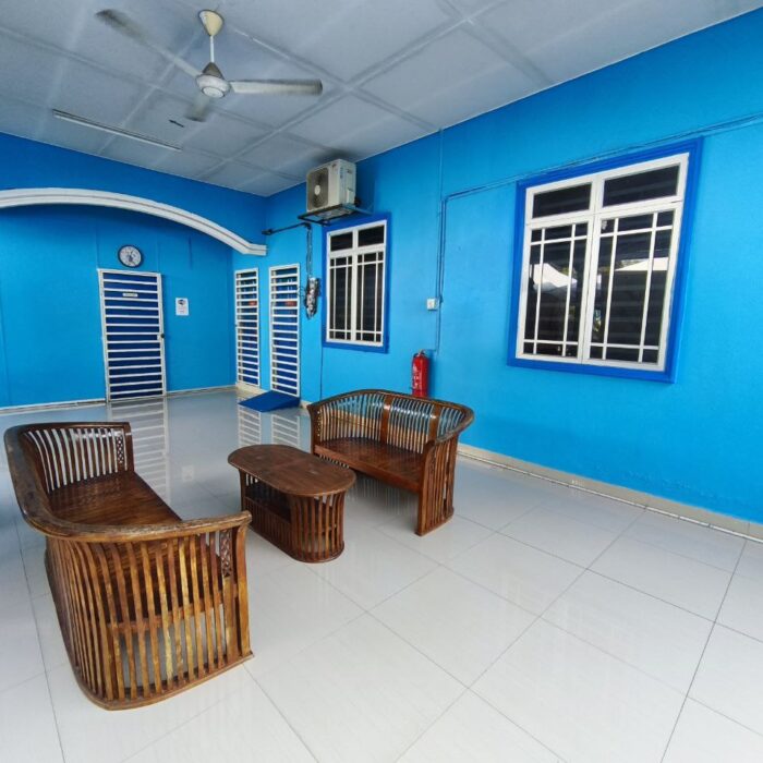 Pandangan luas ruang beranda Homestay KSCC dengan susunan kerusi rotan yang selesa.