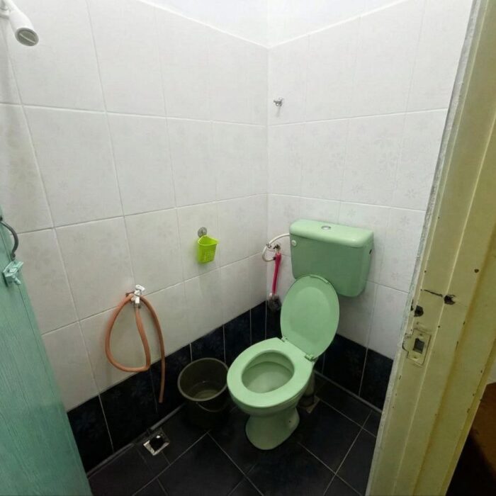 Tandas duduk berwarna hijau yang bersih dan selesa di dalam bilik tidur utama Homestay, Kuala Selangor Cabin Camp (KSCC).