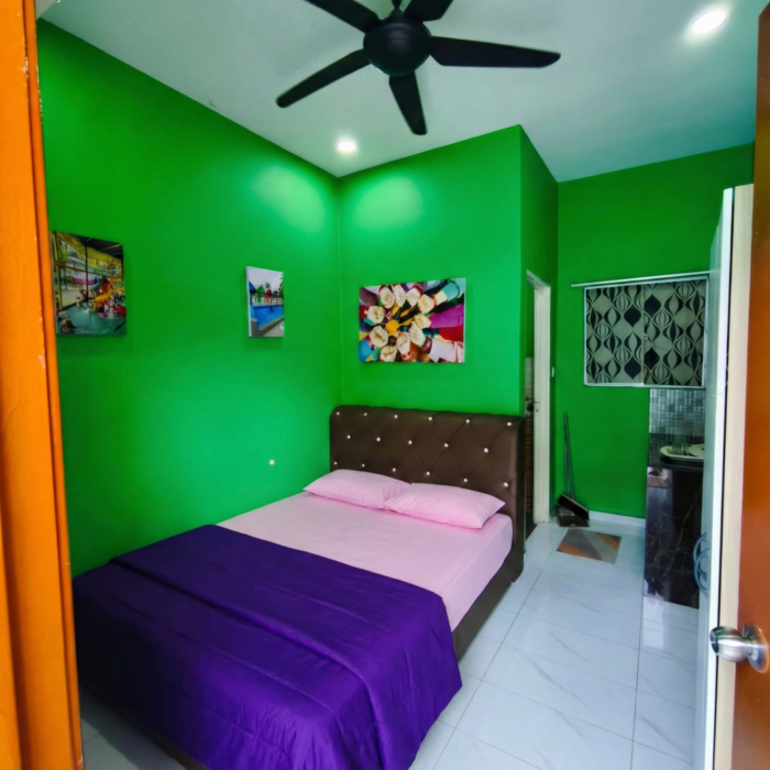 Sudut pandangan dalam unit penginapan Tiny House dengan dinding berwarna hijau terang dan katil yang selesa di Kuala Selangor Cabin Camp (KSCC).