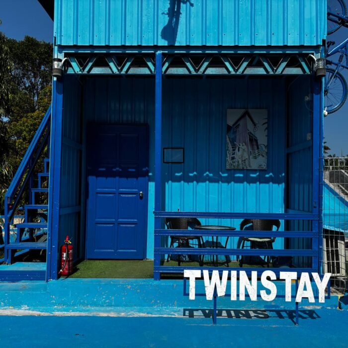 Pandangan hadapan cabin TwinStay berwarna biru yang unik, lengkap dengan ruang santai beranda di Kuala Selangor Cabin Camp (KSCC).
