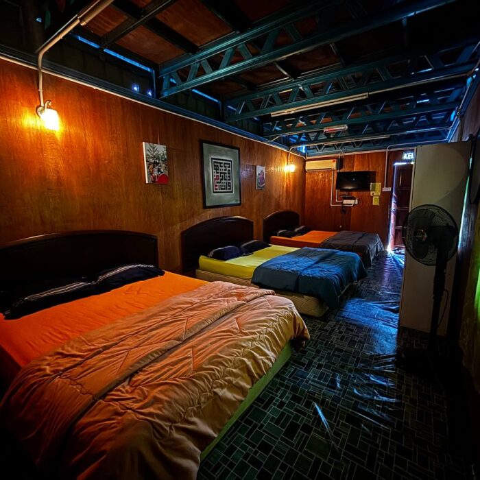 Sudut pandangan dalam bilik TwinStay tingkat bawah yang luas, menampilkan susunan katil yang selesa dan suasana bilik yang tenang di Kuala Selangor Cabin Camp (KSCC).