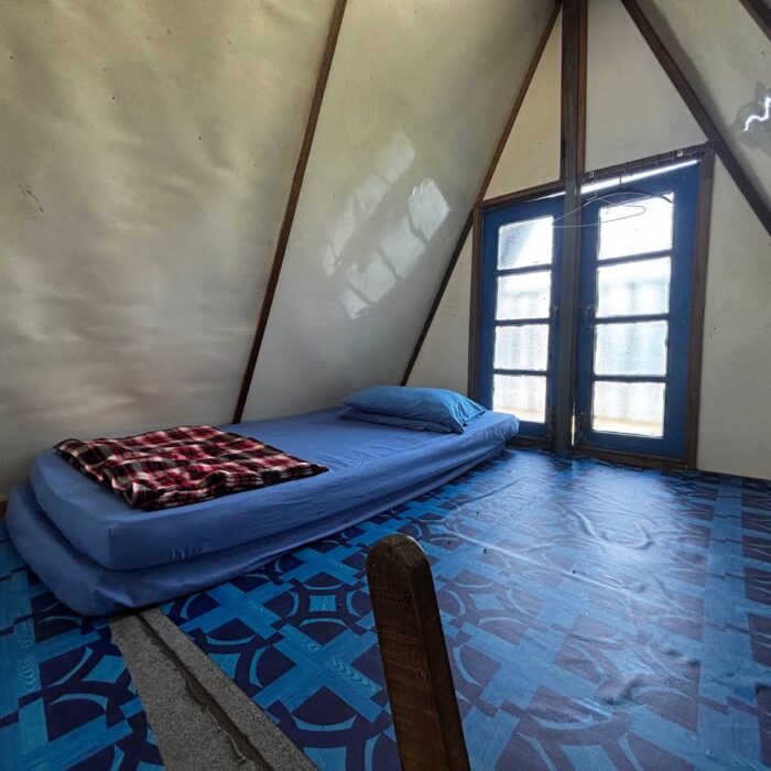 Ruang tidur tingkat atas yang selesa dengan katil bujang dan tingkap kaca di dalam cabin penginapan Type A, Kuala Selangor Cabin Camp (KSCC).