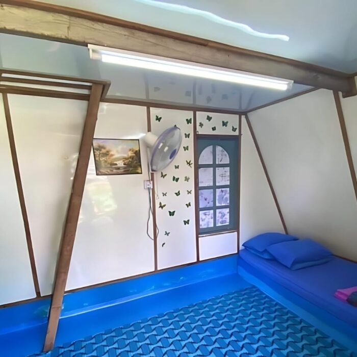 Sudut pandangan dalam ruang tingkat bawah cabin penginapan Type A, lengkap dengan katil bujang dan hiasan dinding di Kuala Selangor Cabin Camp (KSCC).