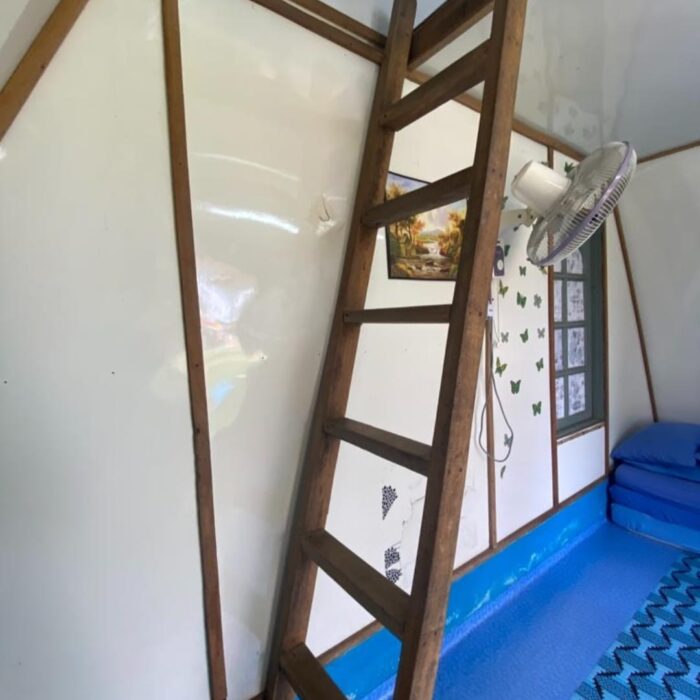 Tangga kayu menuju ke ruang tidur tingkat atas di dalam cabin penginapan Type A di Kuala Selangor Cabin Camp (KSCC).